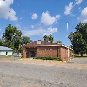 Single story brown brick building with parking lot