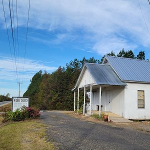 Single story white wooden church building