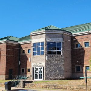 Multistory red brick and stone building with large windows