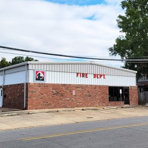 Single story brick and metal building with four garage doors