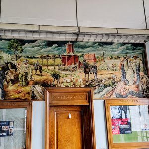 Colorful mural depicting an agricultural scene with people and farm animals