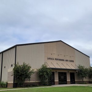 Multistory tan metal building with "Lavaca Performing Arts Center" on front