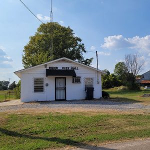 Single story white block building with lettering saying "Rondo City Hall"