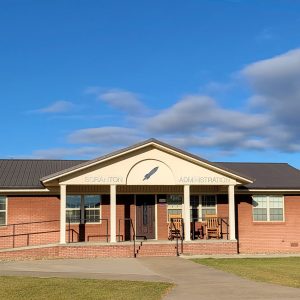 Single story orange brick buildings with ramps and columns