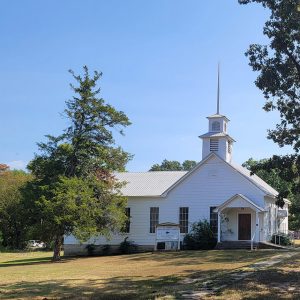 white wooden church building with tall white steeple