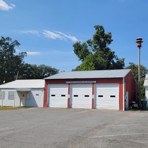 Single story white and red metal buildings with garage bay doors