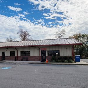 Single-story long metal building with parking lot