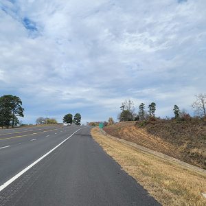 Four-lane highway with turn lane cresting a hill