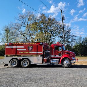 Red fire truck parked in lot beside highway