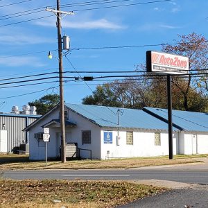 Single story white concrete block building with blue metal roof