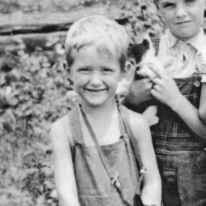 two white boys in overalls holding cats