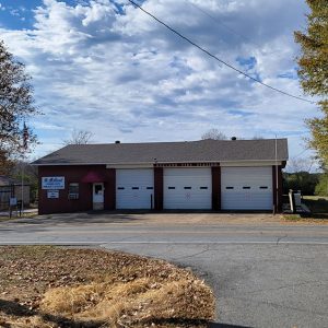 Single story red brick building with three garage doors