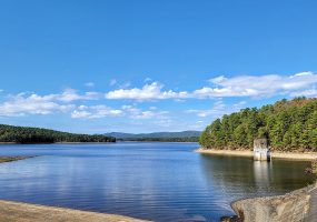 Looking across a lake to a distant shore and a small concrete structure