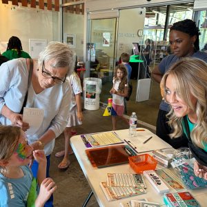 adults talking to a child whose face is painted