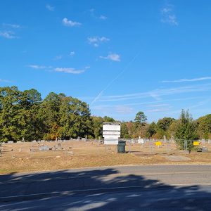 Cemetery behind chain link fence with gravestones