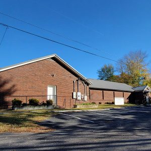 Red brick church building with parking lot