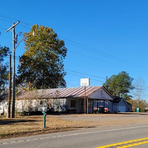 two semis parked next to a dilapidated building with sign saying "Campbell's Grocery"