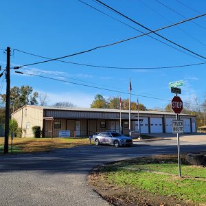 Single story beige metal building with four garage doors