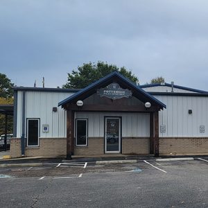 Single story brick and metal police building with covered entrance and parking lot