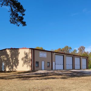 Tan metal building with four garage doors