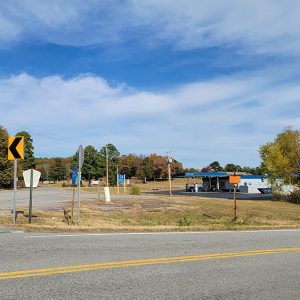 Small town street scene with intersection and one gas station