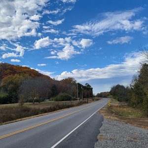 Country highway curving around a tree-covered hillside