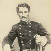 White man with mustache posing in military garb