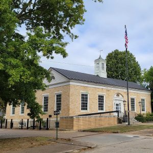 Multistory blond brick post office building with flagpole