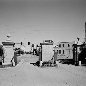 Double entrances with opened iron gates looking out into town beyond