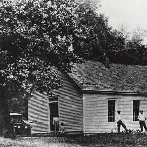 African American people standing around white wooden church building