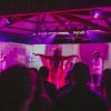 woman in cowboy hat performing and people dancing in front of purple colored stage