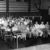 Group of white people sitting in rows of chairs