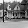 white wooden house with covered entry with narrow pillars