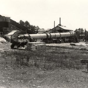 Small sign with date in front of an ore processing plant.