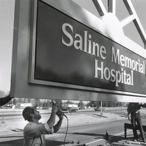 White men hanging a hospital sign