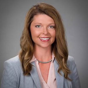 White woman in silver necklace and suit