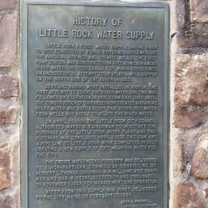 Metal sign saying "Little Rock Municipal Water System Federal Emergency Administration of Public Works Project Ark 1106"