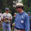 Group of white people in casual clothing and hats standing in the woods