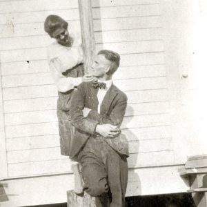 White man and white woman atop a stump