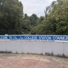 blue sign on wall "welcome to the new College Station community  sponsored by the Progressive League of College Station"