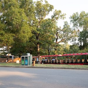 A small red train with trees in the background