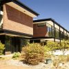 Brick and glass multistory building situated amid trees