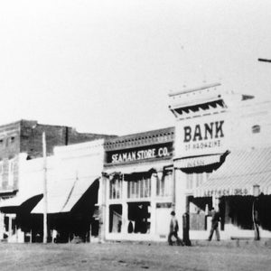 slightly blurry old photo of a small town street with various storefront buildings