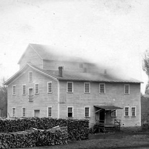 Multistory white building with a smokestack