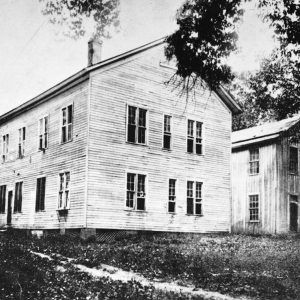 Two multistory white wooden buildings