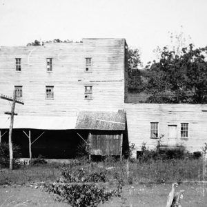 dilapidated multistory wooden building next to a similar one story building