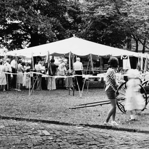 Group of people standing in linebeneath an awning