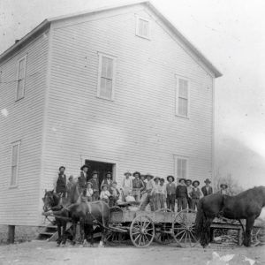 group of people and horse and wagon before multistory wooden building