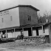 White men on the porch of a multistory milling building "flour meal and feed"