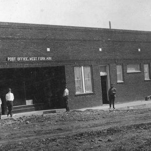 White men standing before a single story brick building